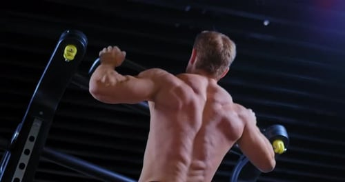 Male Athlete Pulls Himself Up on a Horizontal Bar Relief Muscles of the Back