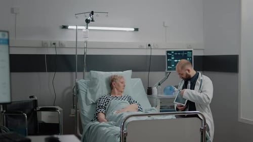 Doctor Consults with Elderly Patient in Hospital Room
