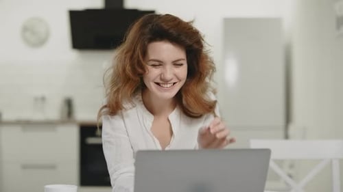 Smiling Woman Working on Laptop at Home