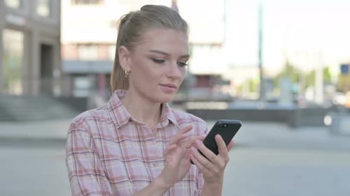 Young Woman Using Smart Phone in the City