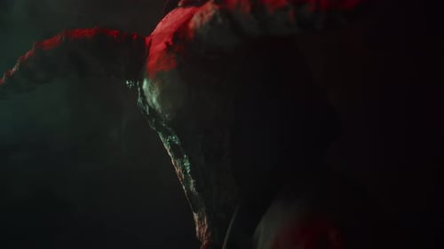 Hooded Figure with Horned Skull in Dark Lighting