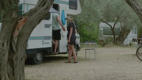 Couple Enters Vintage Camper in a Rural Setting