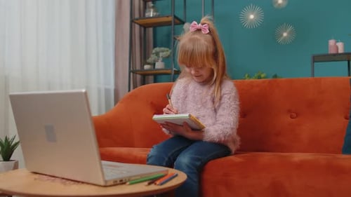 Young Girl Learning Online Using Laptop at Home