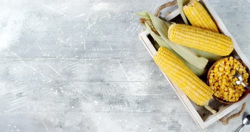 Person Taking Corn Kernels From Bowl With Spoon