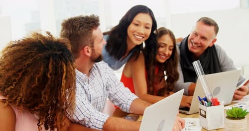 Team of executives interacting with each other while working in the office