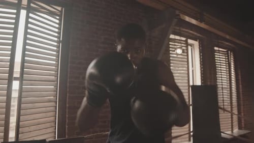 Boxer Training Punching in Boxing Ring