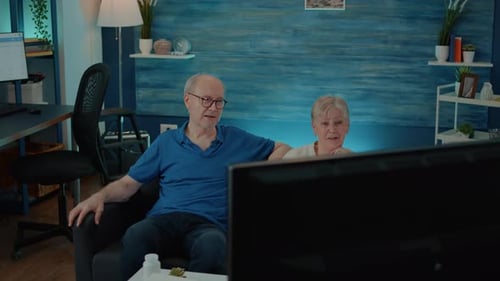 Senior Couple Relaxing on Couch Watching Television Together