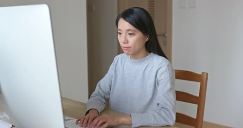 Young Adult Woman Typing on Desktop Computer