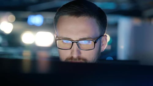 Closeup of a Concentrated Man in Glasses Who Works at a Computer