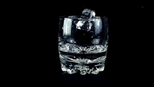 Ice Cubes Falling Into a Glass of Water