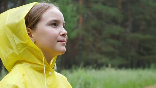 Pensive Girl Looks Away Enjoying Rainy Weather in Forest