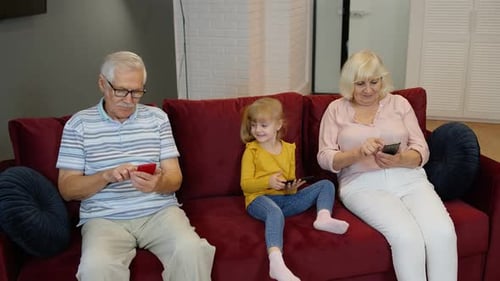 Grandparents and Grandchild Using Technology at Home