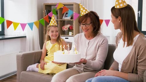 Three Generations Celebrate Birthday with Cake and Candles