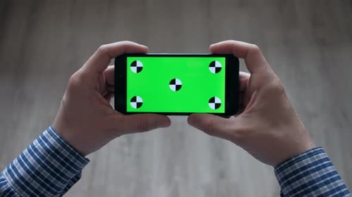 Mann benutzt Smartphone mit Greenscreen zu Hause