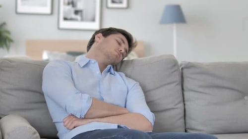 Tired Handsome Young Man Sleeping While Sitting on Couch