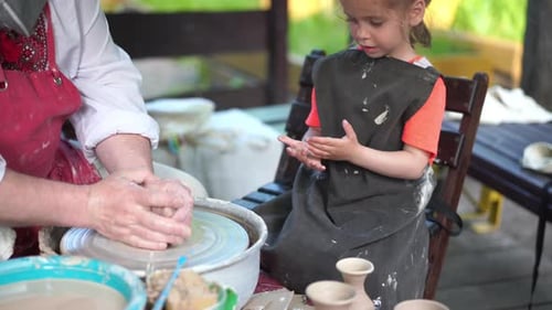 Potter enseigne la poterie à une petite fille