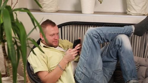 Mann chattet mit Smartphone Liegend auf Sofa liegend Typen Nachricht mit glücklichem Lächeln