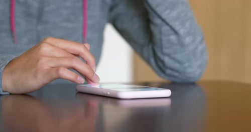 Woman Using Cell Phone on Table