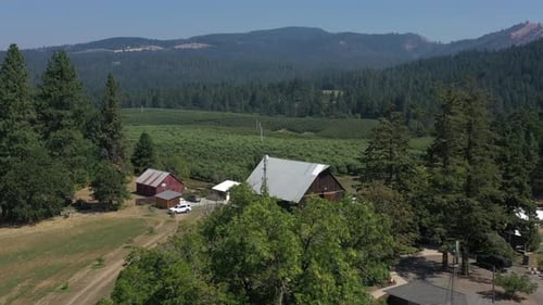 Dramatic flyover of a barn where a wedding ceremony will take place.