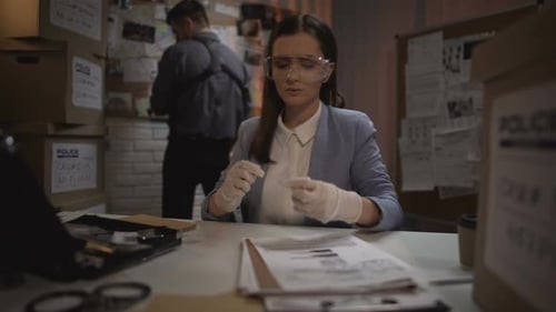 Forensic Analyst Examines Evidence in Crime Lab