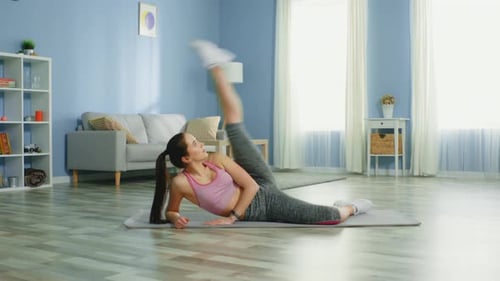 Woman Doing Leg Lifts on Exercise Mat at Home