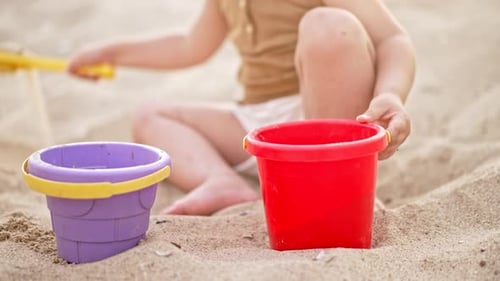 Unrecognizable Baby Child Playing on Beach in Sand with Plastic Toys