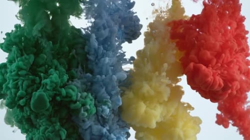 Photo au ralenti d'encre verte, bleue, jaune et rouge s'écoulant dans l'eau, prise avec Phantom Flex 4K ca.