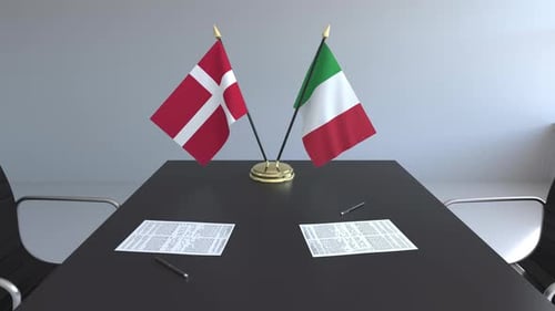 Denmark and Italy Flags on Conference Table for Diplomatic Agreement