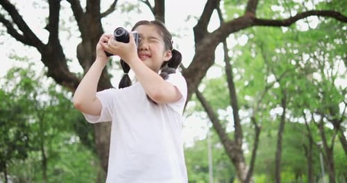 Girl Takes Photos in a Lush Urban Park