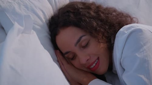 Latino beautiful woman lying down on bed sleeping alone in bedroom in dark night room at home.