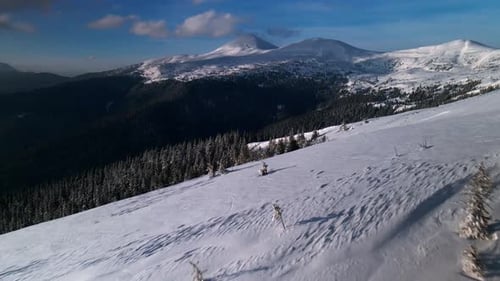 Drohne fliegt über schneebedeckten Kamm und enthüllt das Winterbergtal