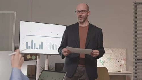 Confident Man Presents Data in Modern Office