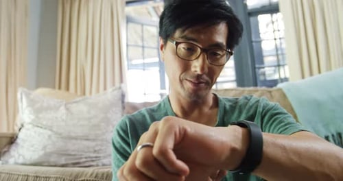 Mann benutzt Smartwatch im Wohnzimmer 4k