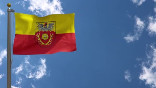 Waving Flag with Coat of Arms Against Clear Blue Sky