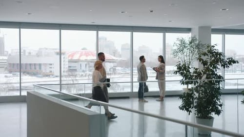 Professionals Walking and Talking in Modern Office Building