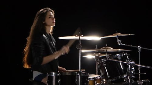 Girl Drummer with Chopsticks Beats Rhythmic Music. Black Background. Side View