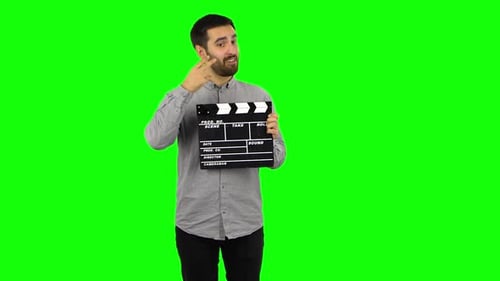 Un chico moreno tiene una película en sus manos. Pantalla verde