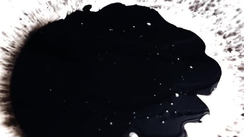 View of dropping black ink on a white paper