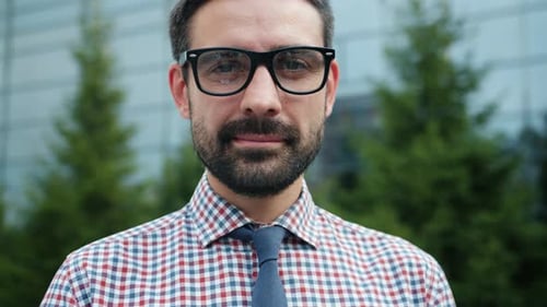 Ralenti d'un homme souriant vêtu de vêtements formels, chemise et cravate, debout dehors