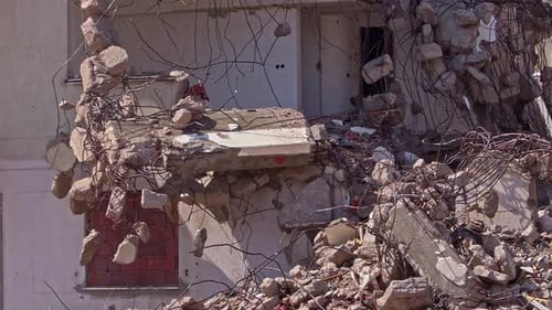 Excavator Demolishing Building with Bucket and Arm