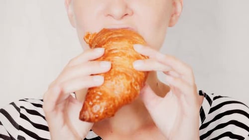 Woman Eating a Croissant Close Up