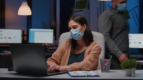 Femme d'affaires bourreau de travail avec masque facial contre Covid19 travaillant dans un bureau de démarrage