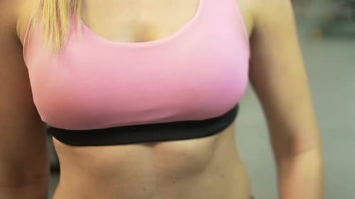 Sporty woman setting up smart watch before starting workout in gym, active life