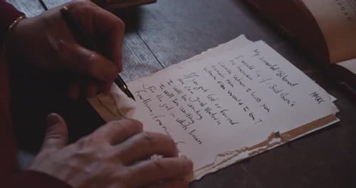 Person Handwriting a Letter Using Parchment Paper and a Fountain Pen