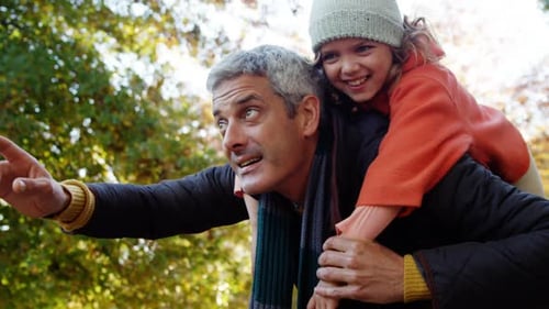 Father and Daughter on Piggyback Ride in Autumn