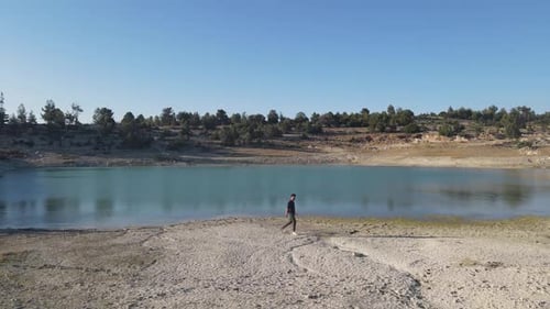 Young Adult Walking on Tropical Lake Shoreline