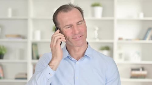 Man Talking on Phone Smiling in Office