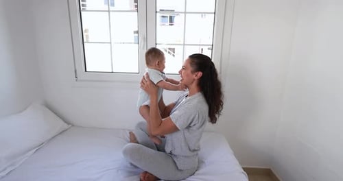 Mother Lifts Baby in Air at Home