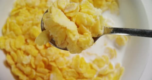 Cornflakes with Milk Spooned from a Bowl