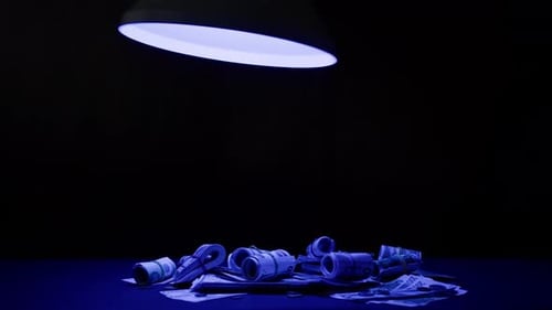 Money Rolls Under Lamp in Vibrant Colors